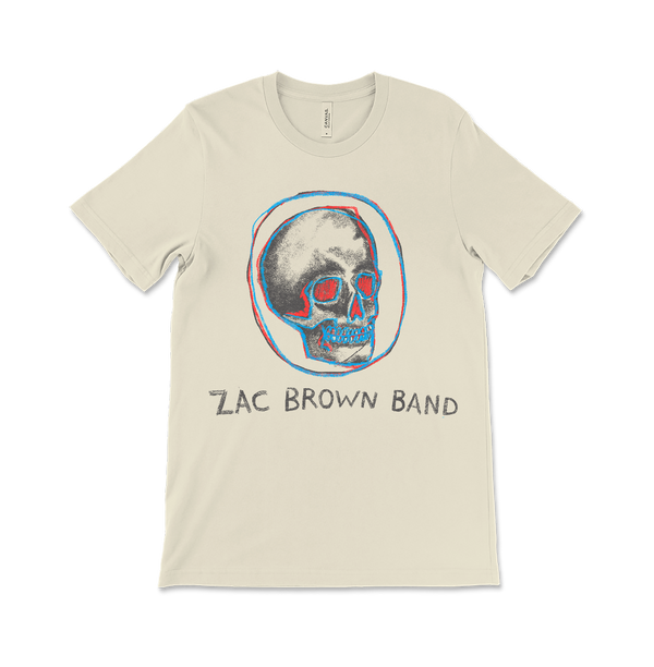 Beige t-shirt featuring a stylized skull design and ’Zac Brown Band’ text.