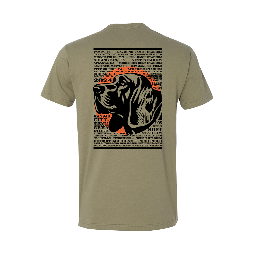 Tan t-shirt with a graphic design featuring a dog’s head and text listing various stadiums and cities.
