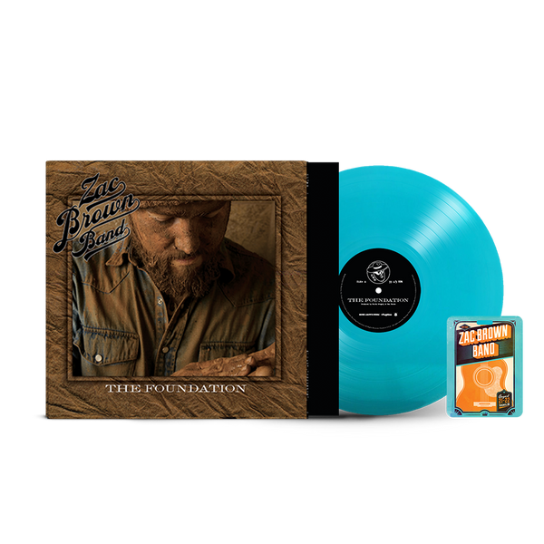 Vinyl record album titled ’The Foundation’ by Zac Brown Band, with a turquoise-colored vinyl disc and accompanying guitar pick package.