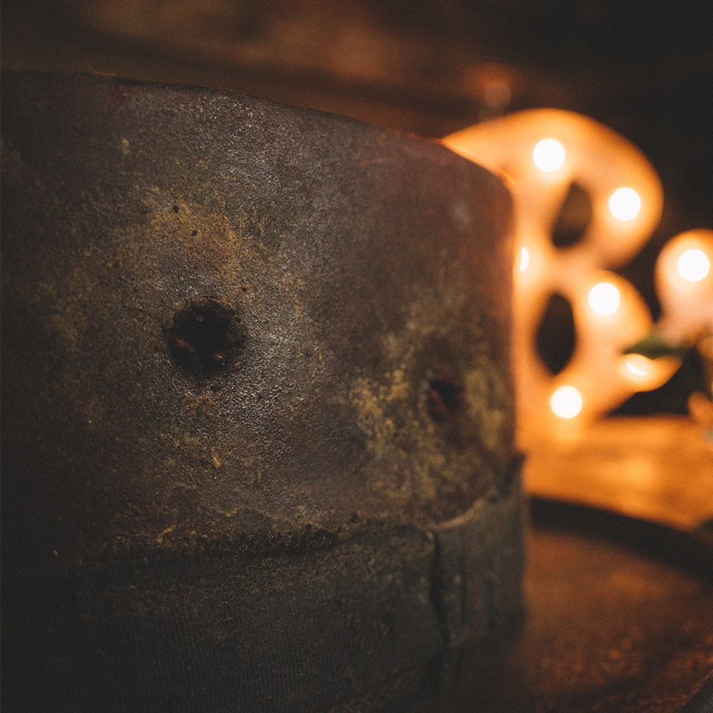 Weathered concrete block with a small hole, positioned near a glowing decorative object.