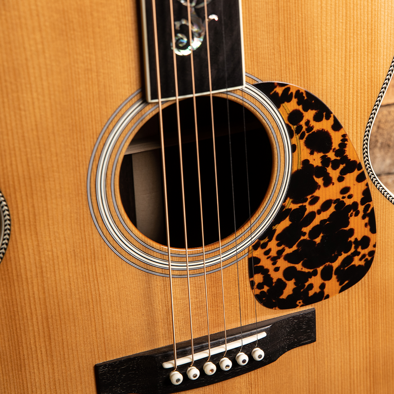 Acoustic guitar with a leopard-print pickguard.